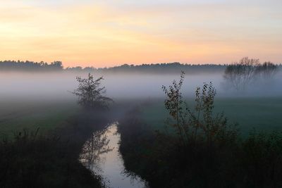 Scenic view of calm lake at sunset