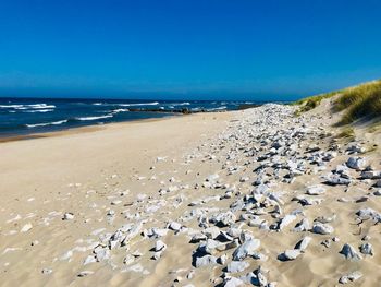 Scenic view of beach against clear blue sky