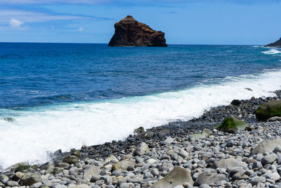 Scenic view of rocks in sea against sky