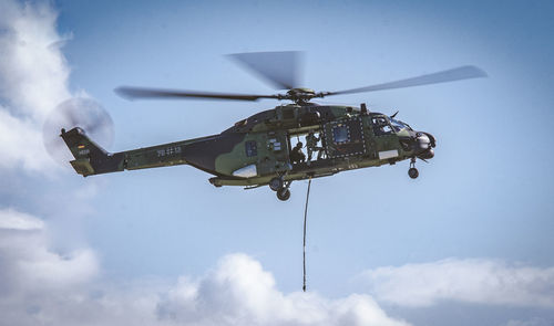 Low angle view of helicopter flying in sky