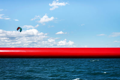 Man flying over sea against blue sky