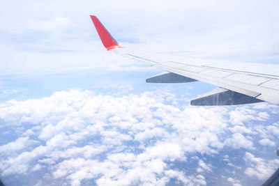 Aerial view of airplane wing over clouds