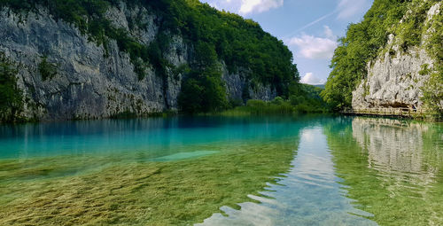 Panoramic view of rocks in water against sky plitvice blue lake in croatia