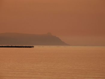 Scenic view of sea against orange sky