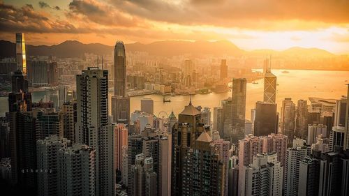 Aerial view of modern buildings against sky during sunset