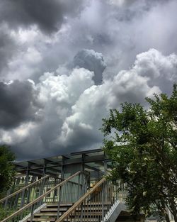 Low angle view of footbridge against cloudy sky