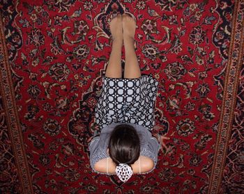 Directly above shot of young woman sitting on carpet