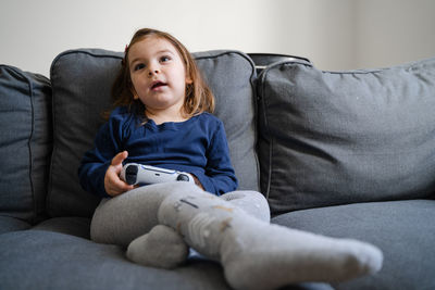 Smiling girl sitting on sofa at home