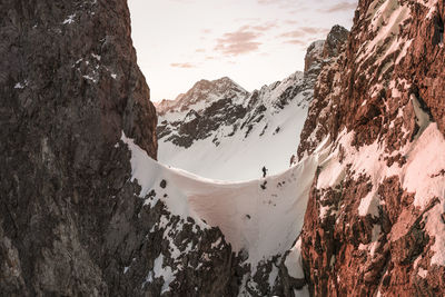 Tourist walking on snow covered mountain at sunrise, ehrwald, tirol, austria