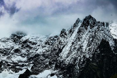 Low angle view of snowcapped mountains against sky