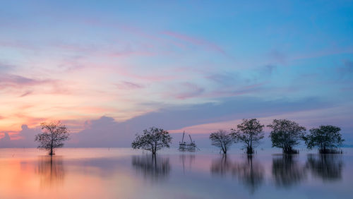 Scenic view of lake against sky at sunset