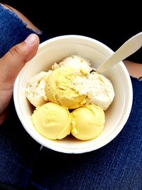 Close-up of hand holding ice cream in bowl