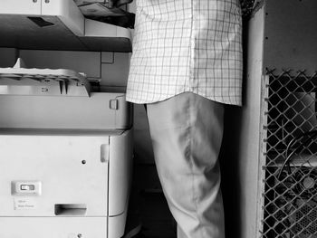 Midsection of man standing by photocopier