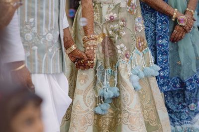 Midsection of bride holding wedding dress