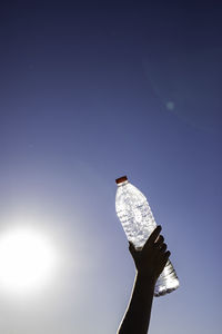 Low angle view of person hand against clear sky