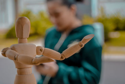 Close-up of woman holding toy while standing on wood