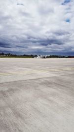 View of airport runway against cloudy sky