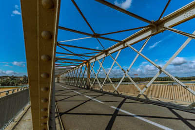 Metal bridge against blue sky with diminishing perspective