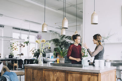 Creative businesswomen discussing at kitchen island in office