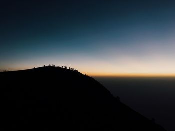 Scenic view of silhouette mountain against clear sky during sunset