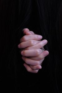 Close-up of woman hand over black background