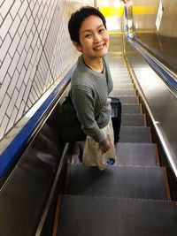 Portrait of boy standing on escalator