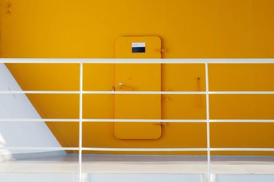 Yellow wall with text on tiled floor in building