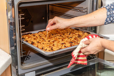 Midsection of woman having food in kitchen