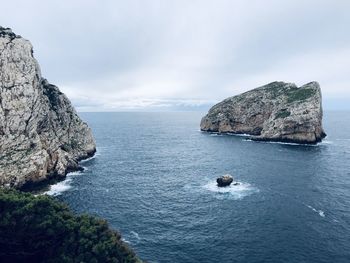 Scenic view of rocks in sea against sky