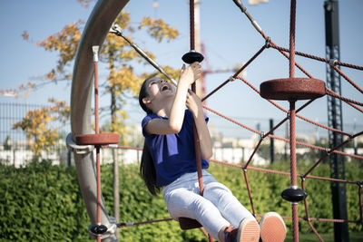 Man sitting on swing at playground