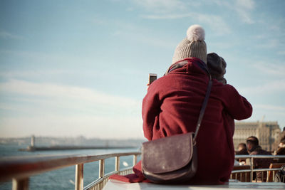 Rear view of mother and daughter looking at sea