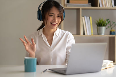 Portrait of a smiling young woman using phone