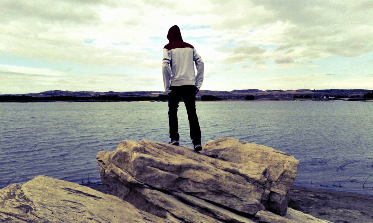 SILHOUETTE OF MAN STANDING ON ROCK