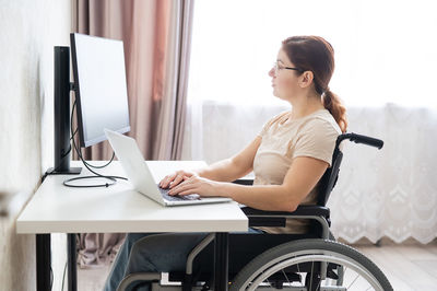 Disabled woman working on laptop at home