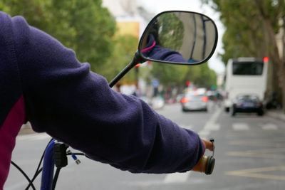 Cropped image of person riding motorcycle on street