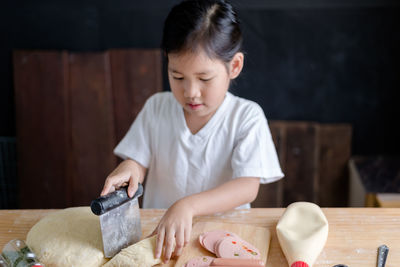 Close-up of girl preparing food on table