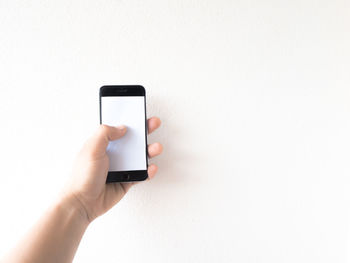 Midsection of person using smart phone against white background