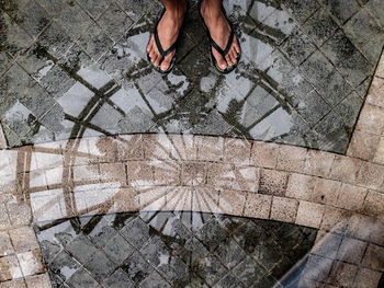 Low section of man standing on tiled floor