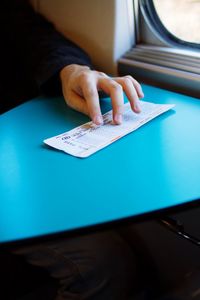 Cropped hand with ticket in train