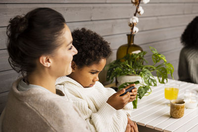 Mother and son sitting at table outdoors