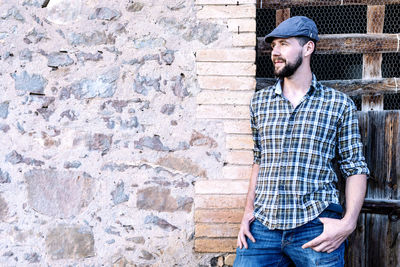 Smiling man standing against brick wall