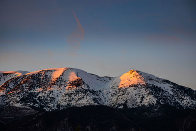 Scenic view of snowcapped mountains against sky during sunset