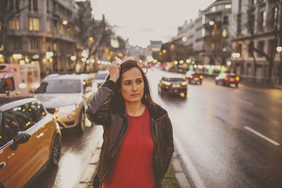 Woman standing on road in city