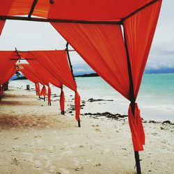 Red flag on beach against sky