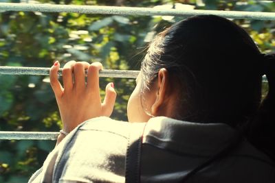 Rear view of woman holding camera