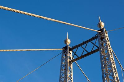 Low angle view of crane against clear blue sky