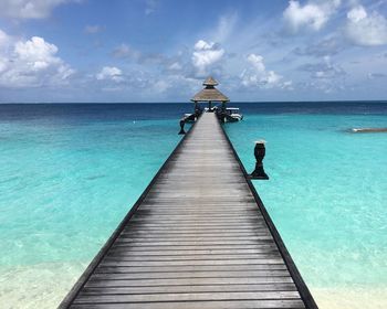 View of pier on sea against cloudy sky