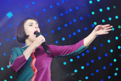 Full length of woman standing against illuminated lights