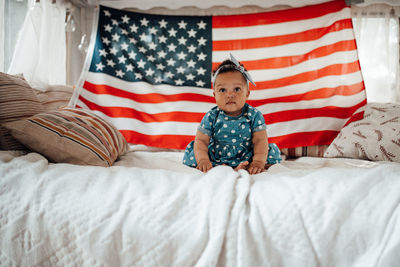 Cute girl sitting against american flag