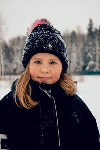 Girl in snowy hat looking at camera